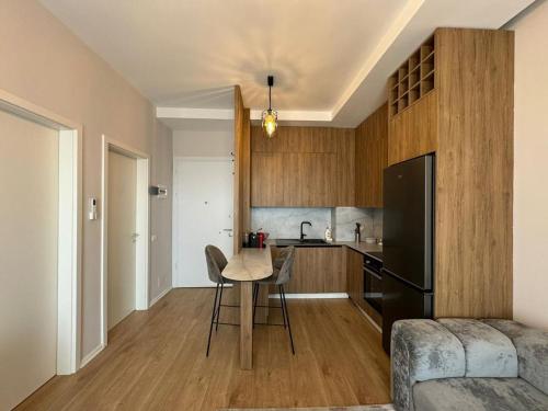 ティラナにあるTirana Center Boulevard Apartmentのキッチン(テーブル、黒い冷蔵庫付)