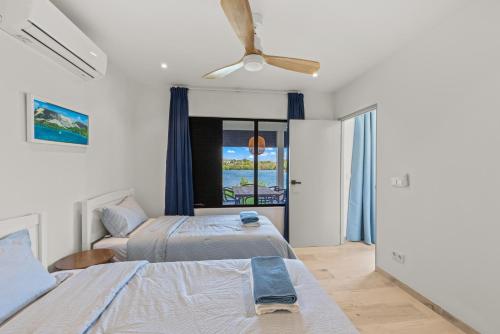 a bedroom with two beds and a ceiling fan at Dolce Vita Beach, Waterfront Bungalows with Private Beach in Willemstad