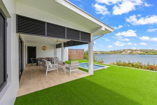 a view of the backyard of a house with green grass at Dolce Vita Beach, Waterfront Bungalows with Private Beach in Willemstad