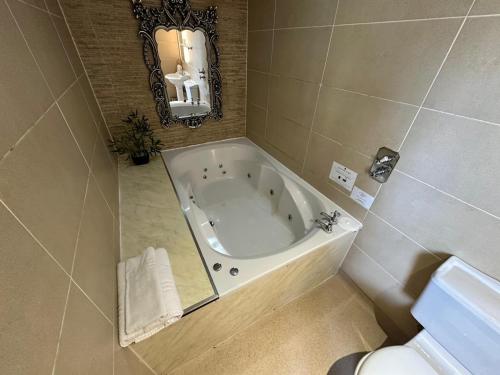 a bath tub in a bathroom with a mirror at White Star Line Hotel in Liverpool