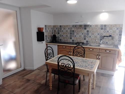une cuisine avec une table et des chaises dans l'établissement La Loge de Fleur, à Anglars-Saint-Félix