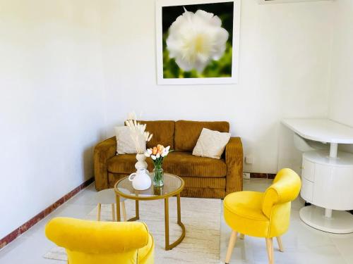 un salon avec un canapé, deux chaises et une table dans l'établissement Maison indépendante 52 m2, clim, wifi et jardin, à La Londe-les-Maures