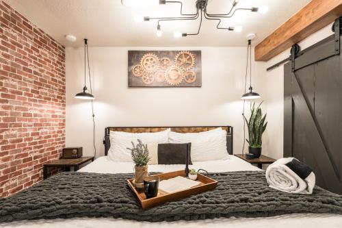 a bedroom with a bed with a brick wall at Awaken Your Senses King Bed Bsu Parking in Boise