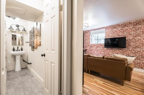 a living room with a brick wall and a couch at Awaken Your Senses King Bed Bsu Parking in Boise