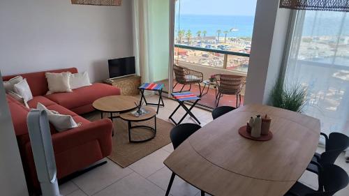 un salon avec un canapé et une table dans l'établissement Vue mer et port 6eme etage Magnifique !, à Saint Cyprien Plage