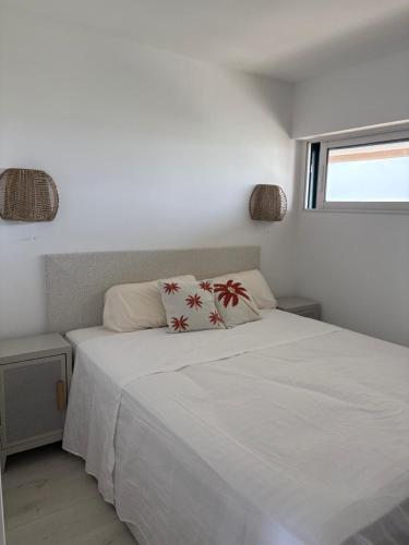 une chambre avec un lit blanc et une fenêtre dans l'établissement Vue mer et port 6eme etage Magnifique !, à Saint Cyprien Plage