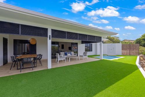 a patio with a table and chairs and grass at Dolce Vita Beach, Waterfront Bungalows with Private Beach in Willemstad
