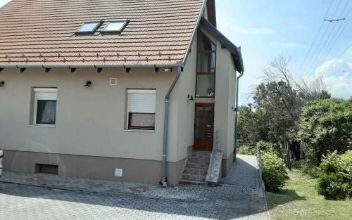 una casa blanca con techo rojo y puerta en Apartments in Badacsony - Balaton 50626, en Badacsony