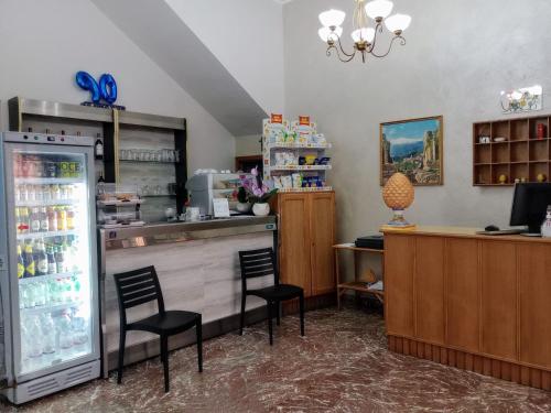 a bar with two chairs and a refrigerator at Hotel Pensione Cundari in Taormina