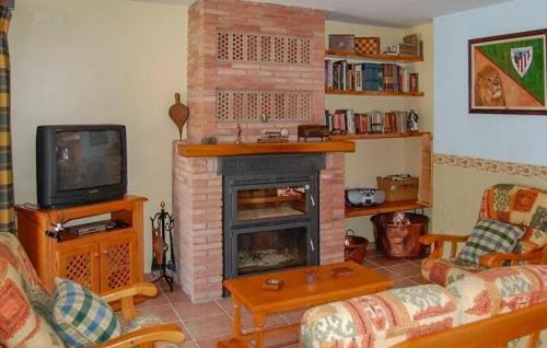 a living room with a fireplace and a tv at 6 Bedroom Cozy Home In Cofrentes - Ebv244 in Cofrentes