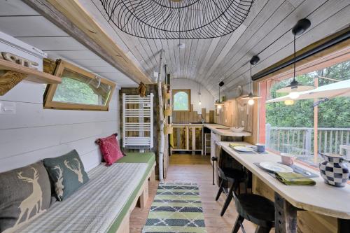 une petite maison avec un long banc et une table dans l'établissement Roulotte Appoline, à Arrien-en-Bethmale