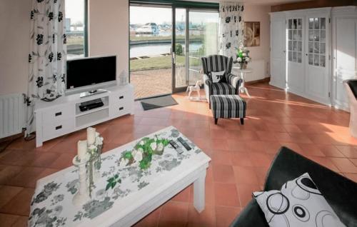 ein Wohnzimmer mit Fernseher, Couch und Tisch in der Unterkunft Three Bedroom Awesome Home In Lemmer in Lemmer