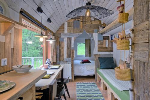 a room with a kitchen and a bedroom with a bed at Roulotte Appoline in Arrien-en-Bethmale