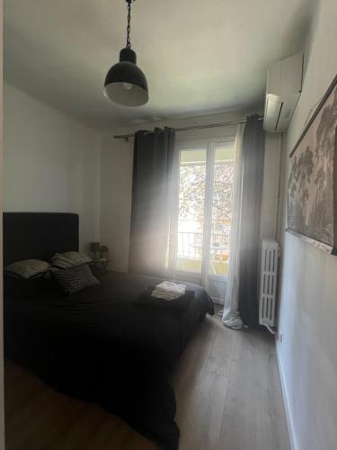 une chambre avec un lit noir et une fenêtre dans l'établissement Aix centre - Appartement Cosy avec Terrasse et Clim, à Aix-en-Provence