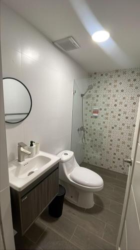 a bathroom with a white toilet and a sink at Hotel Boutique Brisas Colonial in Santo Domingo