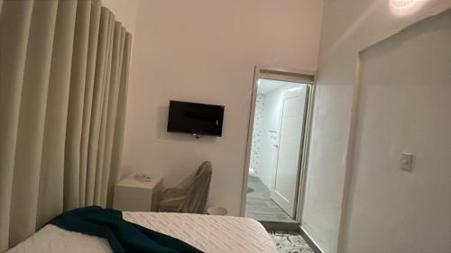 a bedroom with a bed and a mirror and a television at Hotel Boutique Brisas Colonial in Santo Domingo