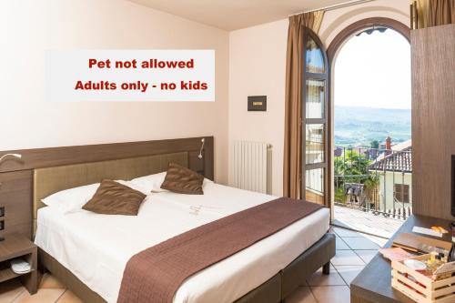 a bedroom with a bed and a large window at Le Torri - Castiglione Falletto in Castiglione Falletto