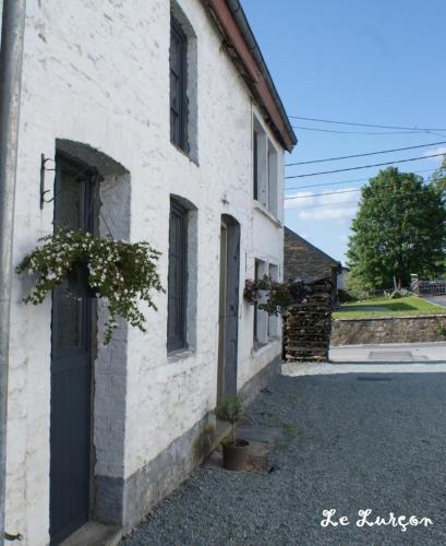 a white building with a door and a window at Holiday home le Lurçon et la Lurcette in Libin