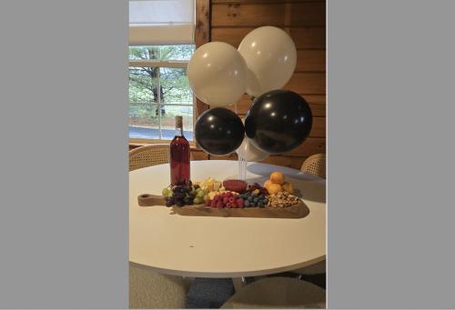 a table with balloons and a plate of fruit at Sage Brush Cabin in Millersburg