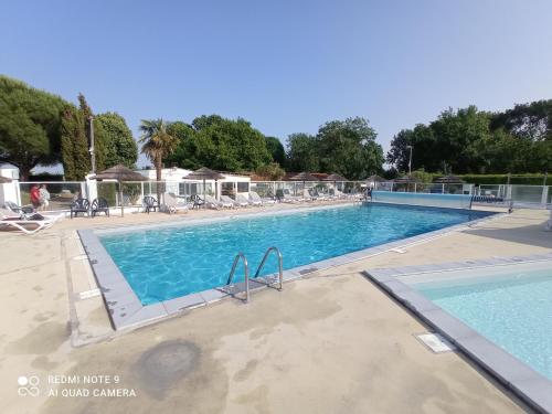 a large swimming pool with blue water at Mobilhome 4-6 personnes confort-piscine-mer meschers sur gironde in Meschers-sur-Gironde