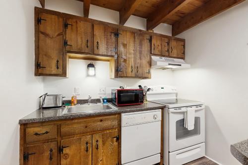 a kitchen with wooden cabinets and a sink at Quechee Hollow 2C in Quechee