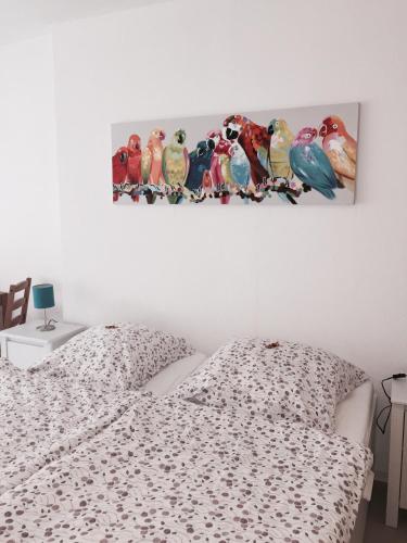a bedroom with a bed with birds on the wall at Pension Lindenhof in Limburg an der Lahn