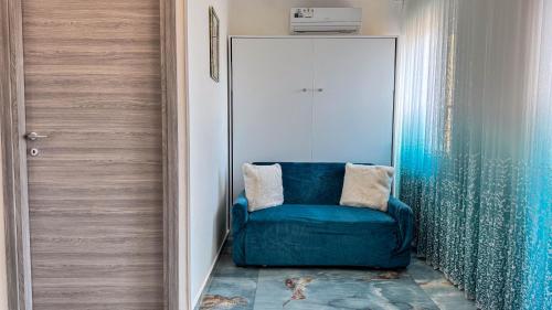 a blue chair in a room with a door at B&B Antenna 2 by Ca-Sa Check in Chioggia