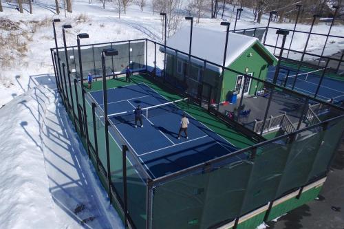 two people playing tennis on a tennis court in the snow at Quechee Hollow 2C in Quechee