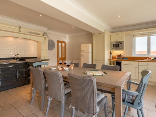 a kitchen and dining room with a wooden table and chairs at 4 Bed in West Runton 81469 in West Runton