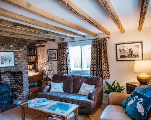 ein Wohnzimmer mit Couch und Kamin in der Unterkunft Abbey Gate Cottage, Faversham Near to Whitstable in Kent