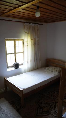 a bed in a room with a window at Motina River Guesthouse in Tropojë