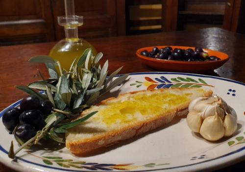 a plate with a sandwich and some olives and garlic at Urlaub, wo die Toskana noch authentisch ist - Rustico aus 16Jh mit Infinity Pool in Pomarance