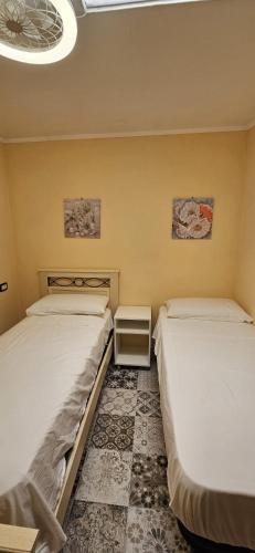 two twin beds in a room with at Catullo Bags&Beach in Cozze