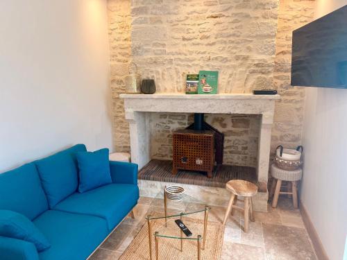 a living room with a blue couch and a fireplace at Gîte de la porcelaine, 4 pers in Giey-sur-Aujon