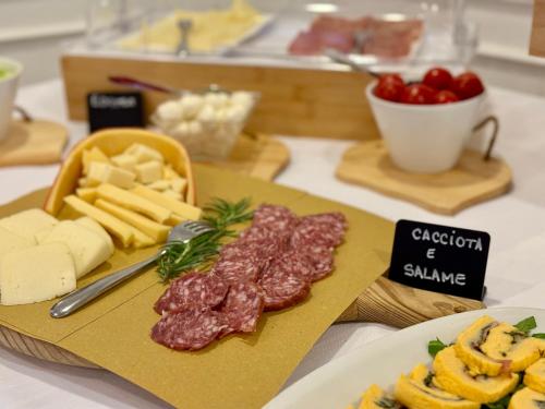a table with cheese and meat on a cutting board at Hotel Gaby in Rimini
