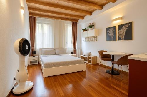 Un dormitorio con una cama y una mesa y sillas. en Cozy Apartment Center, en Bérgamo