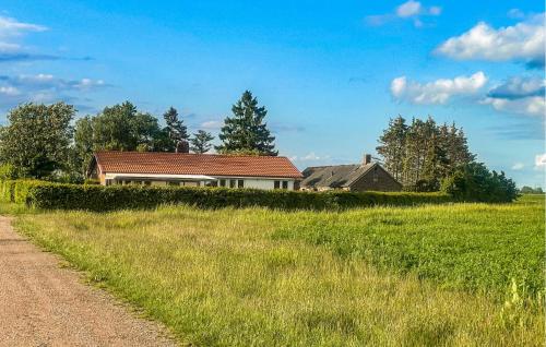 a house in a field next to a dirt road at 2 Bedroom Beautiful Home In Fleninge - S12280 in Fleninge