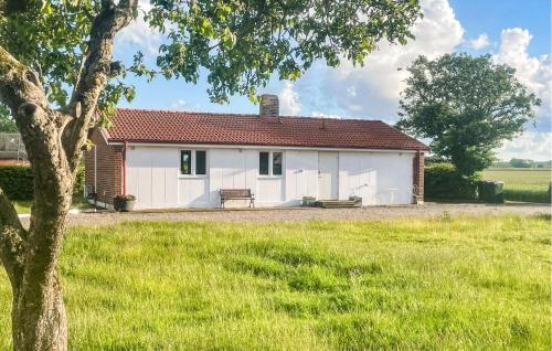 a white house with a bench in a field at 2 Bedroom Beautiful Home In Fleninge - S12280 in Fleninge