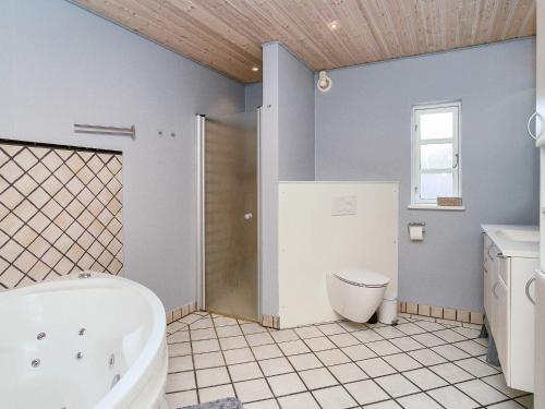 a bathroom with a tub and a toilet and a sink at 9 person holiday home in Jægerspris-By Traum in Jægerspris