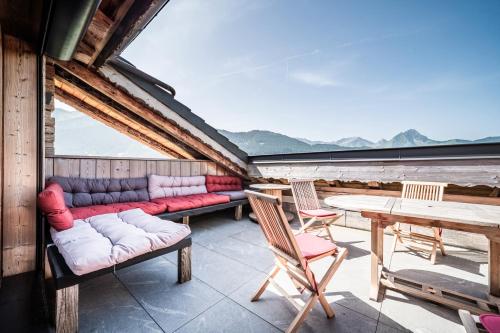 a porch with a couch and chairs and a table at Le Perray Alpine Lodge in Abondance