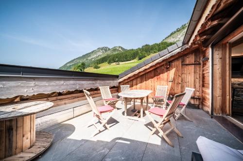 a patio with a table and chairs on a building at Le Perray Alpine Lodge in Abondance