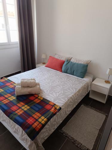 - une chambre avec un lit et une couverture colorée dans l'établissement Calvi centre ville, à Calvi