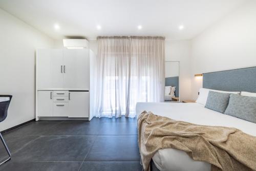 a bedroom with a large white bed and a couch at NG Guest House il Gallura in Olbia