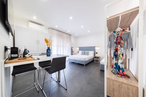 a kitchen and living room with a desk and a bedroom at NG Guest House il Gallura in Olbia
