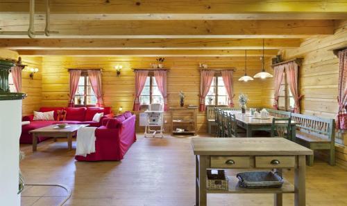a living room with red furniture and wooden walls at Roubená chalupa Lysečinky A in Trutnov
