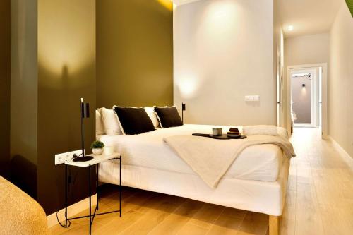 a bedroom with a large white bed with a side table at SariStays Valencia City Center L in Valencia