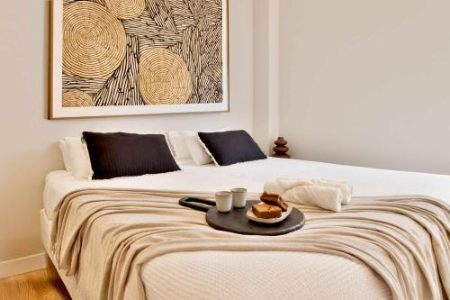 a white bed with a tray of food on it at SariStays Valencia City Center L in Valencia