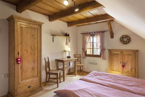 a bedroom with a bed and a table and a desk at Roubená chalupa Lysečinky A in Trutnov
