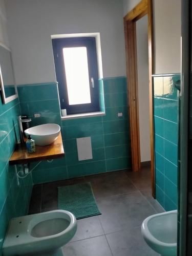 a bathroom with two toilets and a sink and a window at Contrada Cafaro in Salerno