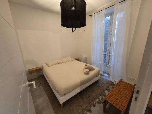 a small bedroom with a bed and a window at Appartement Le Cœur de Nîmes Secteur Arènes Parking Offert ! in Nîmes